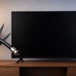 Scissors cutting a cable in front of a black television screen, symbolizing the transition from traditional cable TV to modern IPTV streaming services.